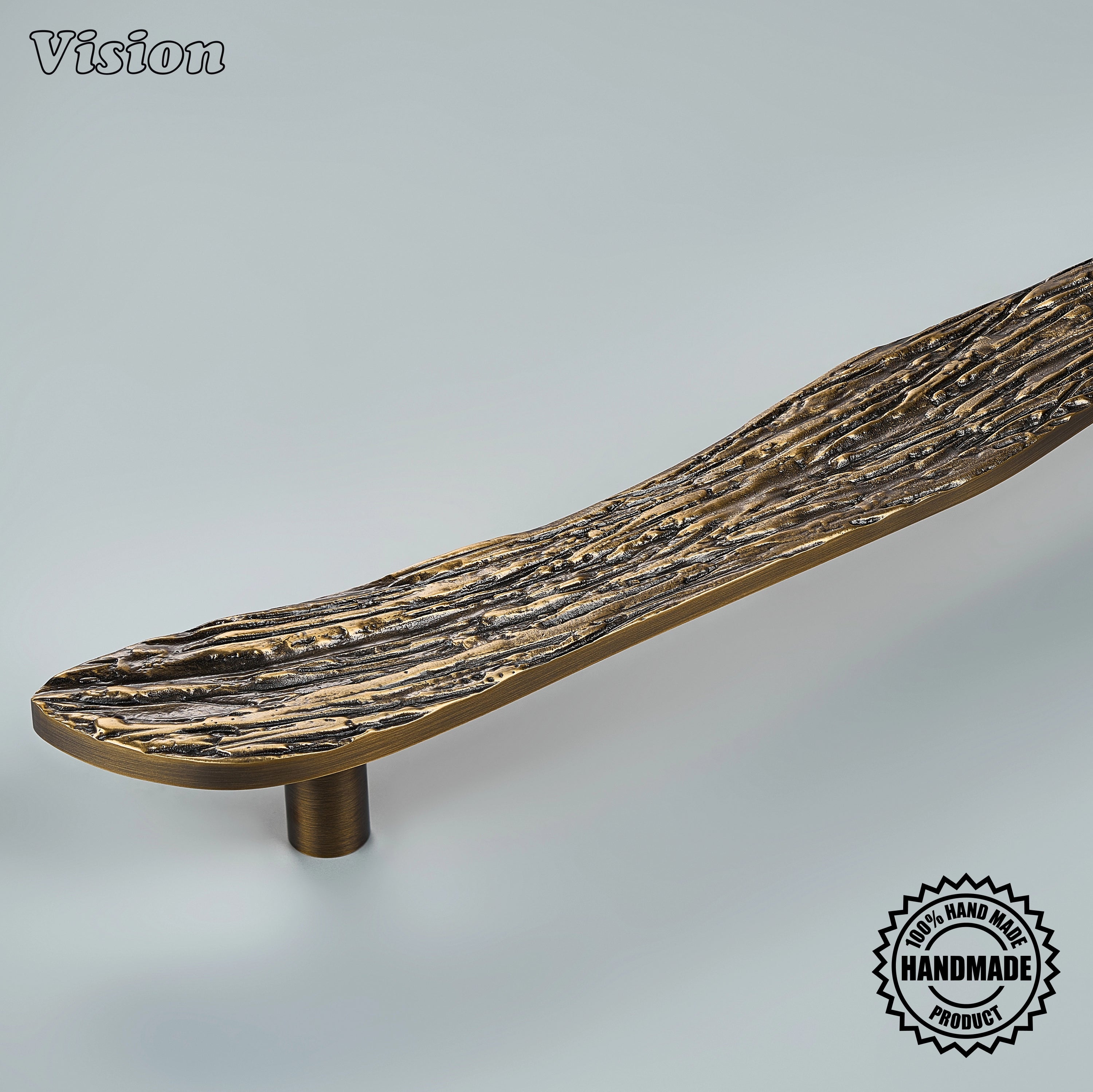 Sculpted antique bronze appliance handle with weathered branch relief on panel-ready refrigerators