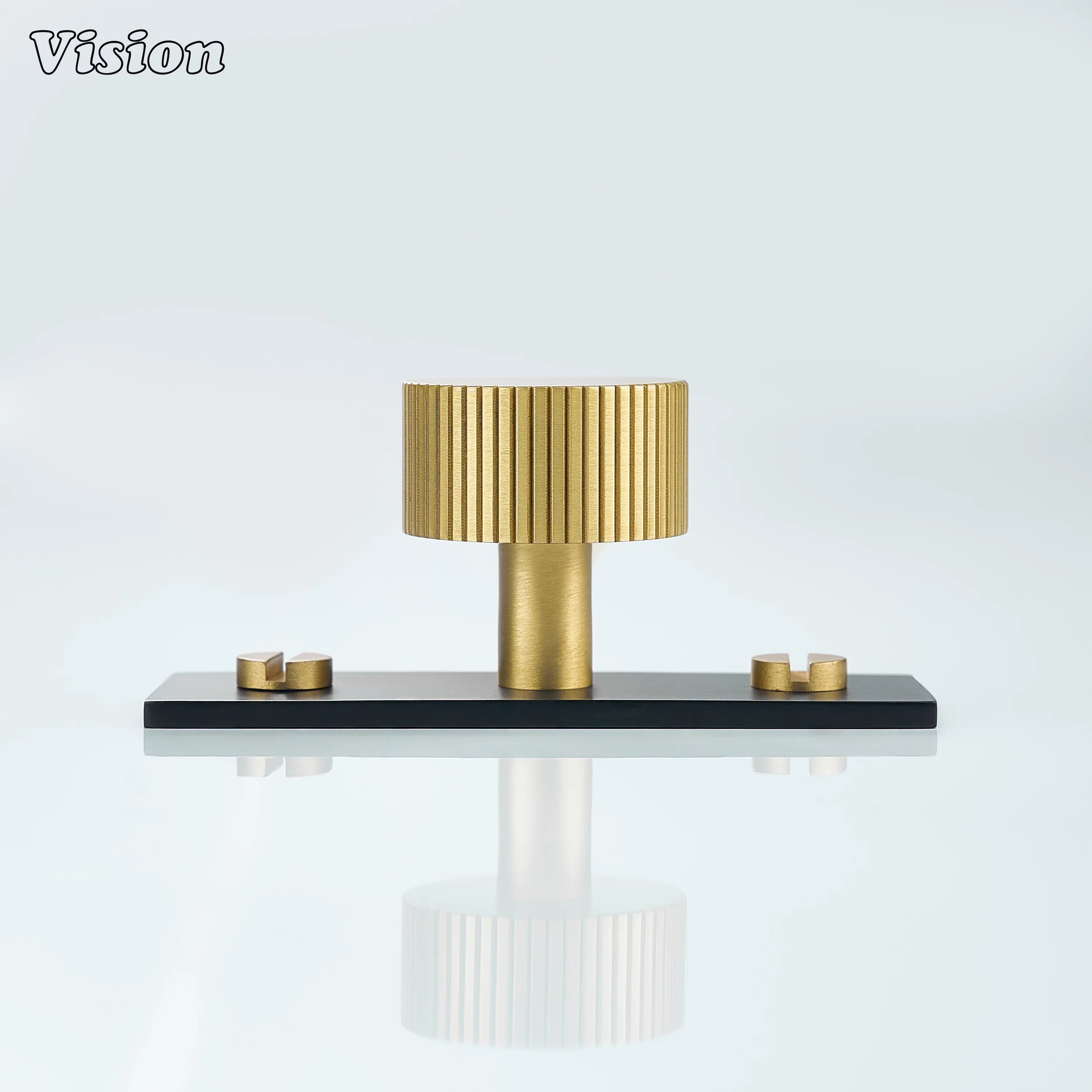 Gold Aris knob with black backplate mounted on cabinet