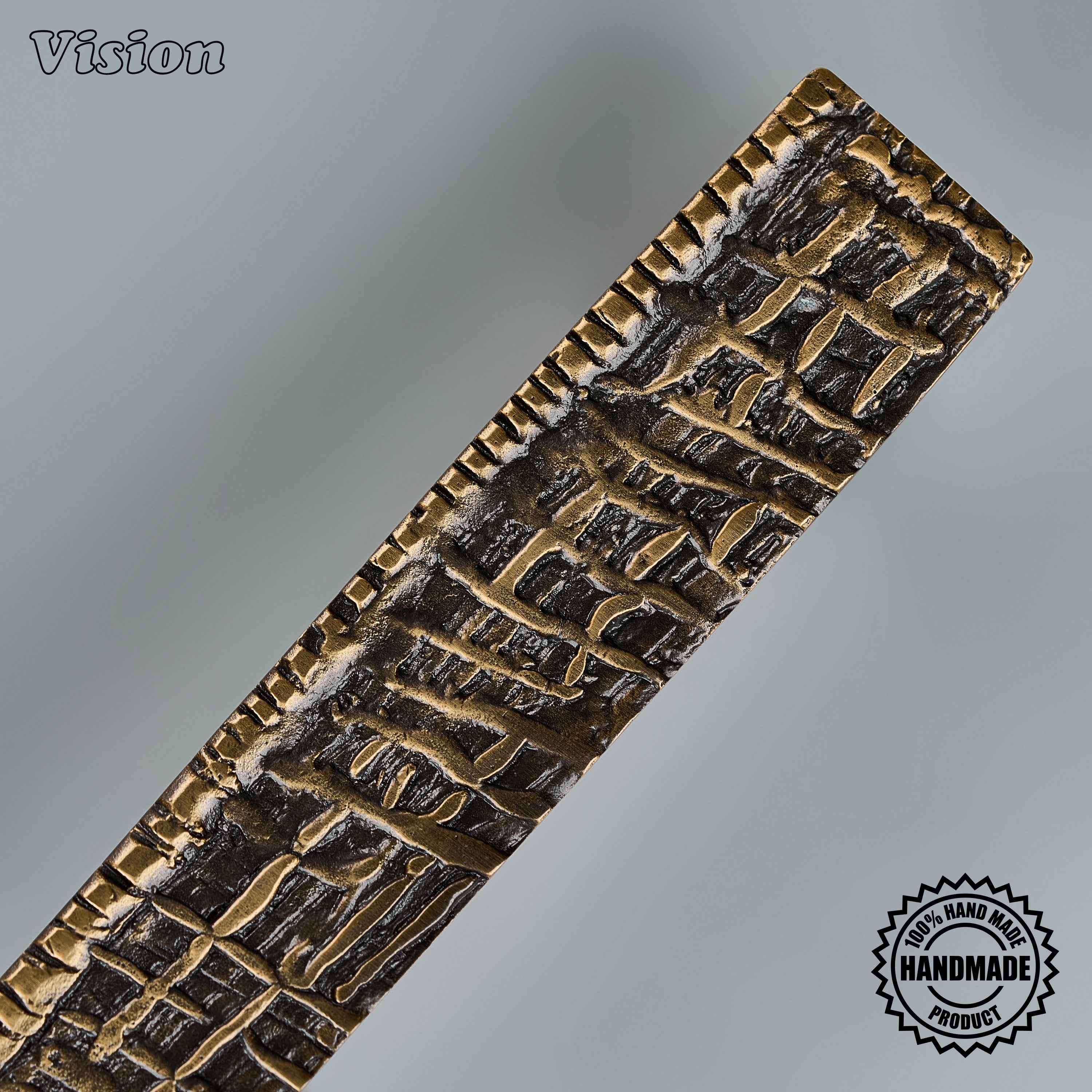 Textured antique bronze sculpted pull handle with intricate woven details on custom paneled appliances