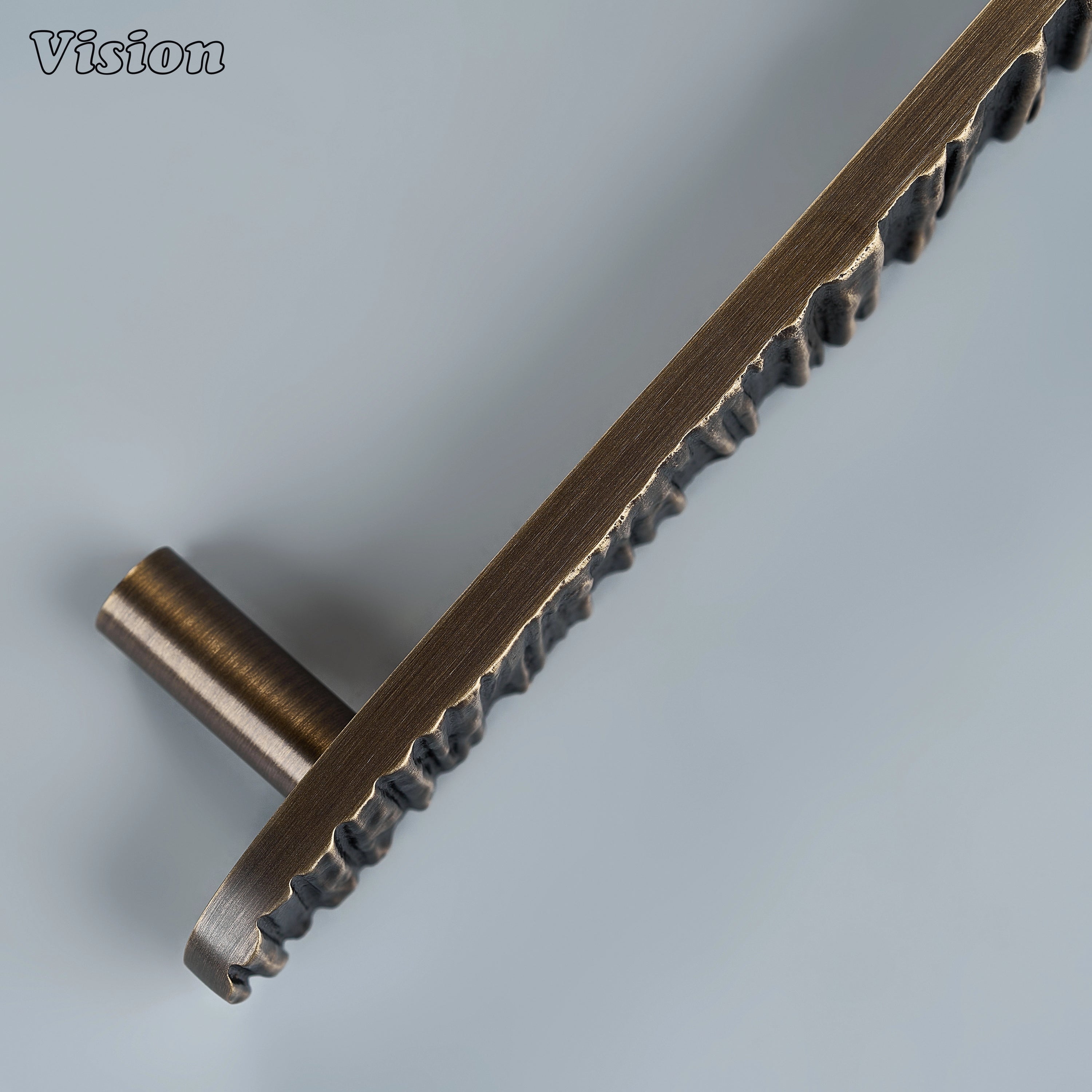 Textured antique bronze sculpted drawer pull with deep bark ridges on custom kitchen cabinetry