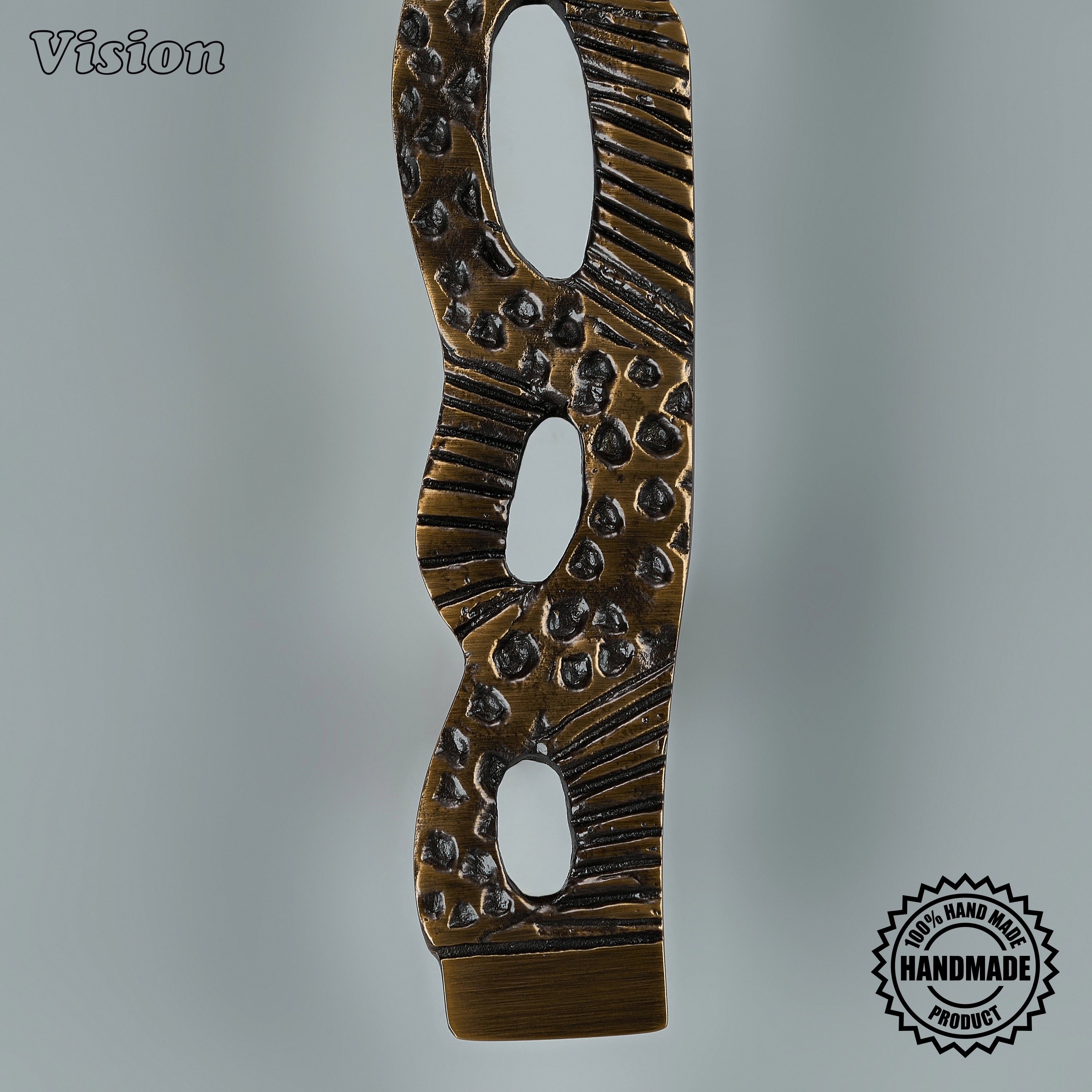 Textured antique bronze sculpted pull handle with interlocking details on custom paneled appliances