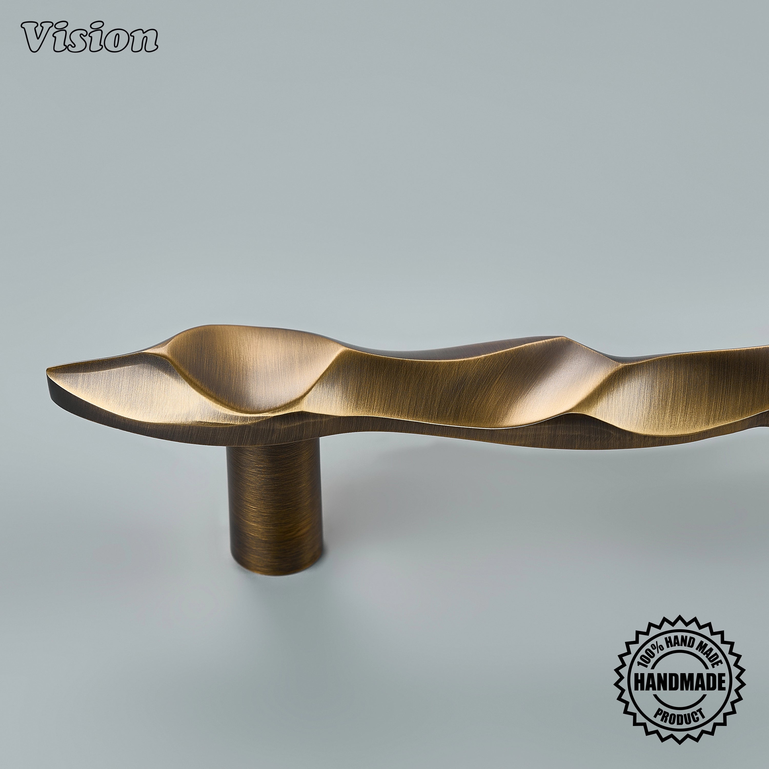 Sculpted antique bronze appliance pull handle with undulating bar profile on paneled freezers