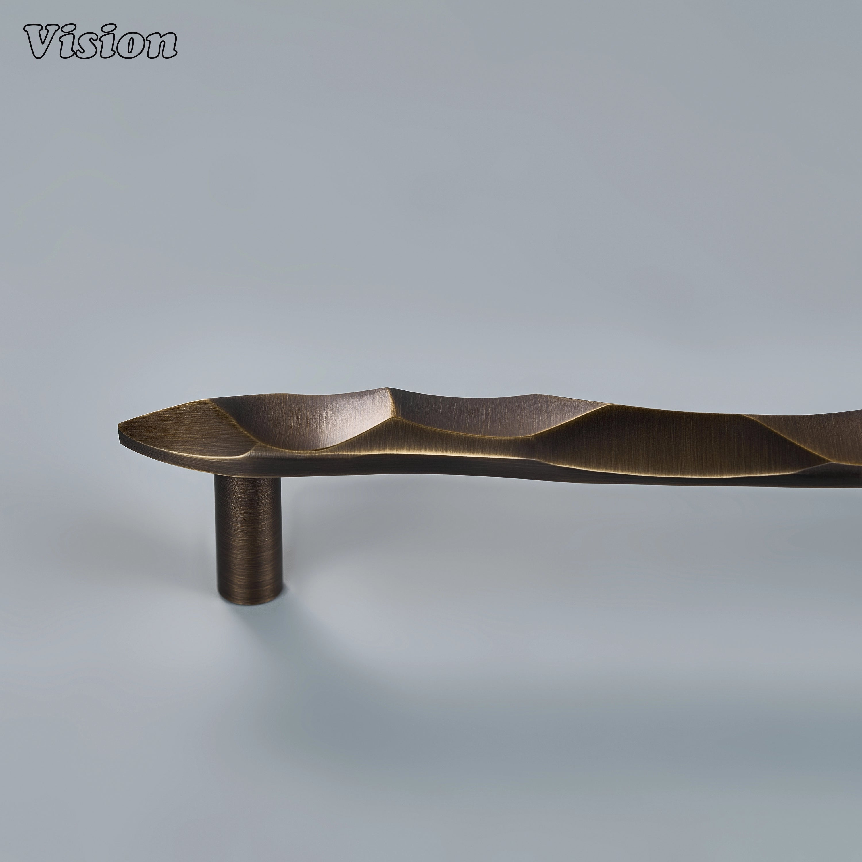 Textured antique bronze sculpted drawer pull with undulating curves on custom kitchen cabinetry