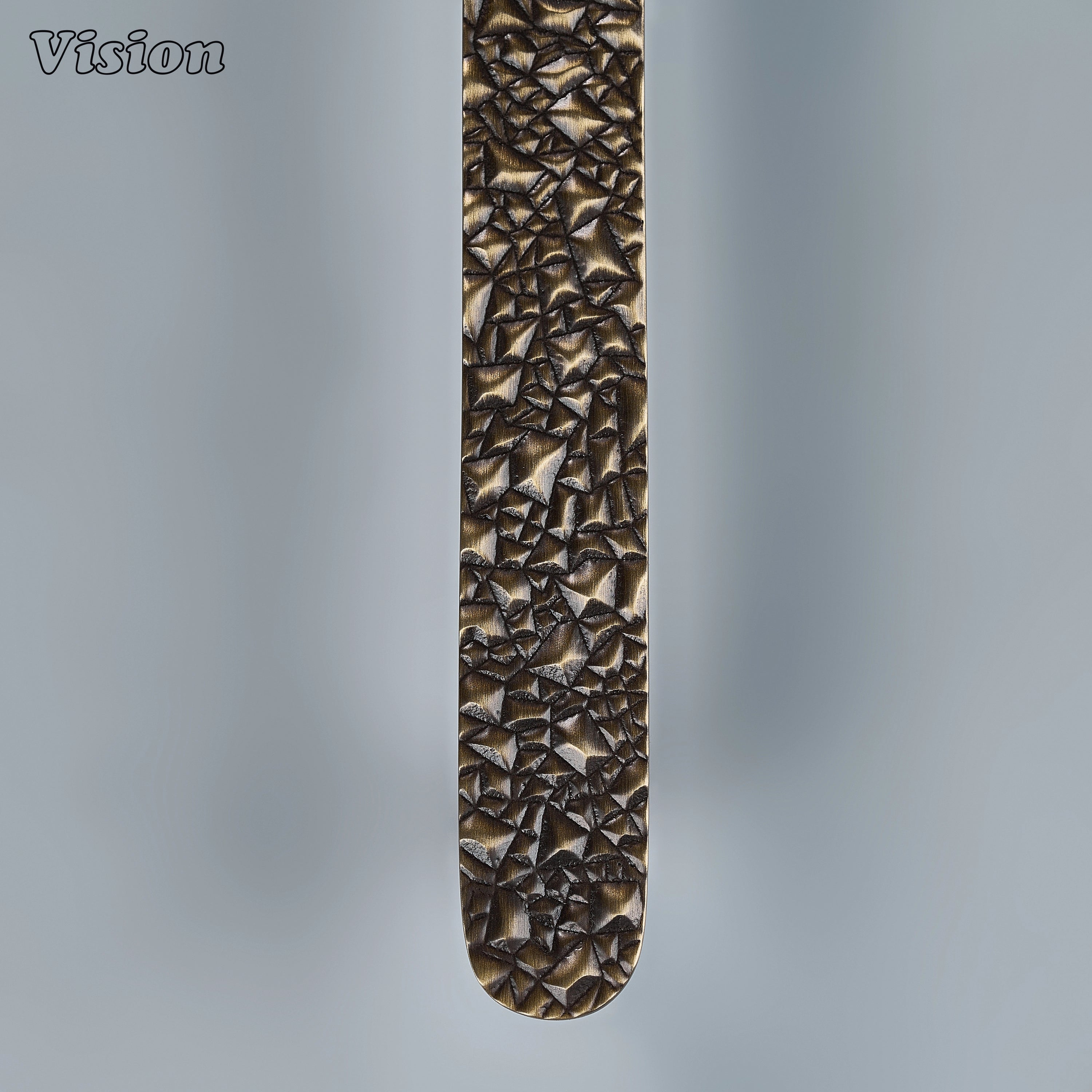 Textured antique bronze sculpted drawer pull with crushed rock ridges on custom kitchen cabinetry