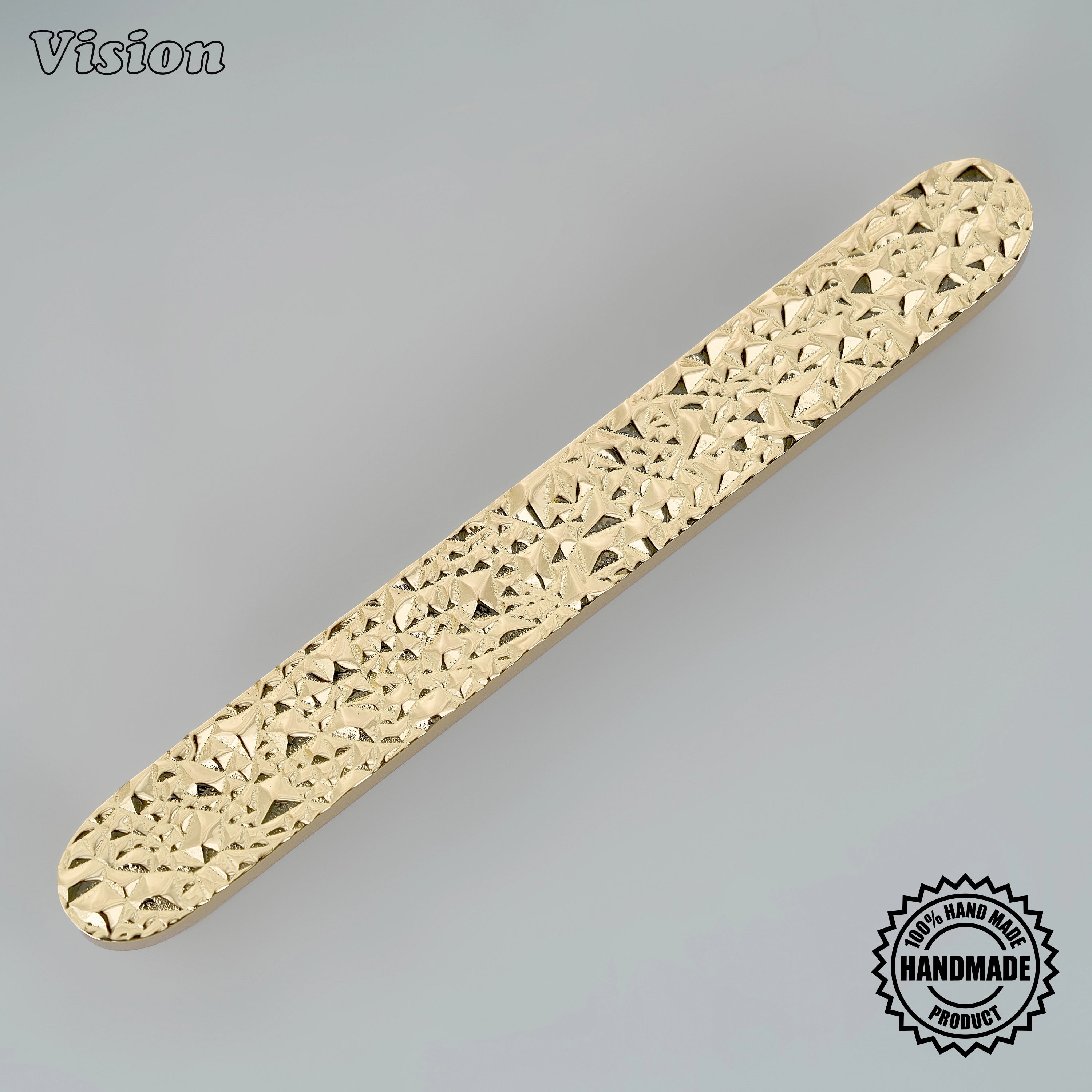 Polished brass cabinet handle featuring a handcrafted tactile chiseled surface for dressing tables