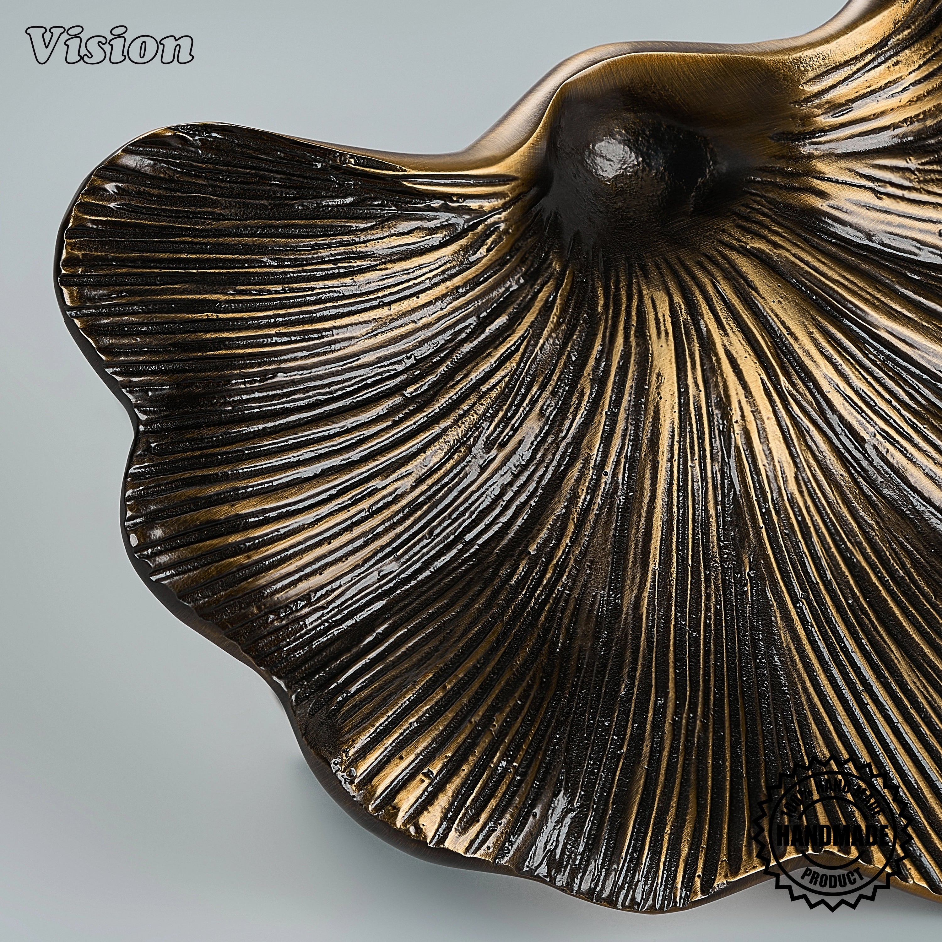 Sculpted antique bronze door handle with shell-inspired fan silhouette on grand entry doors