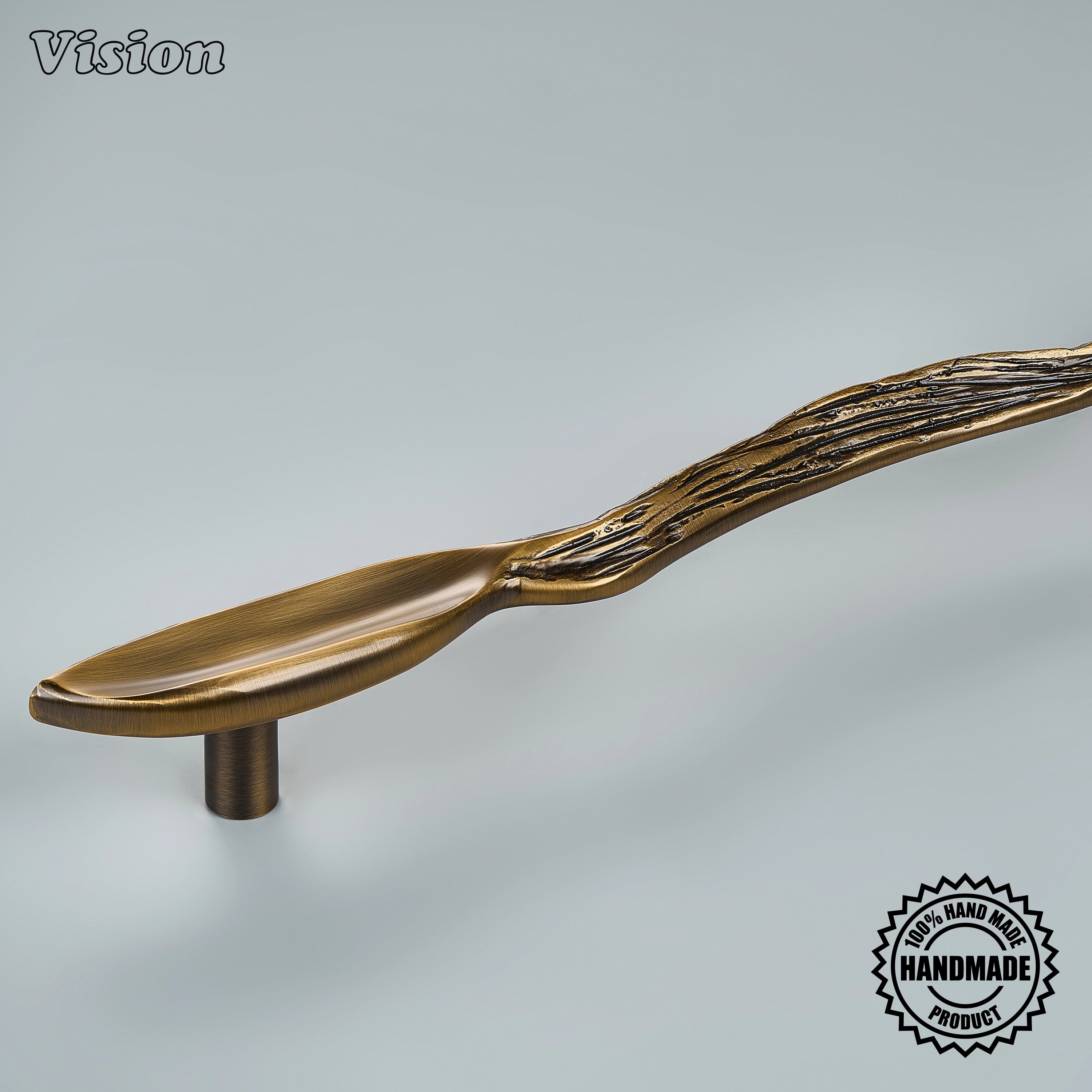 Sculpted antique bronze door handle with botanical pod-like relief on panel-ready refrigerators