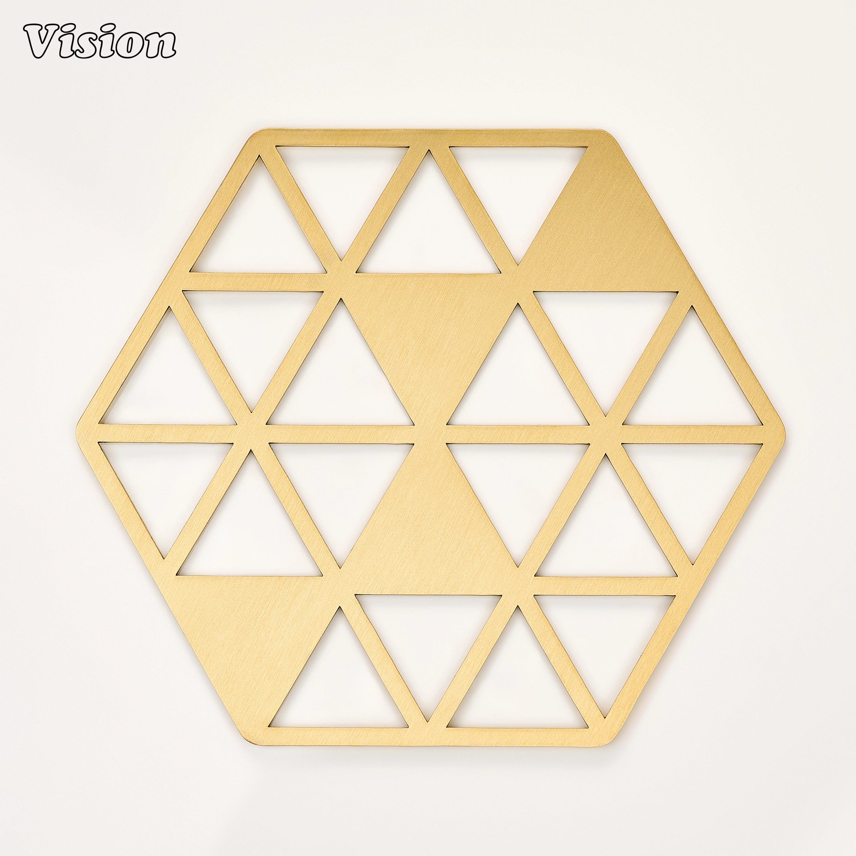 Gold solid brass hexagon coaster with geometric intersecting triangles on a modern dining table